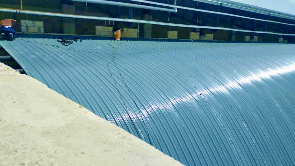 Close-up of curved blue aluminium roofing panels showing quality finish